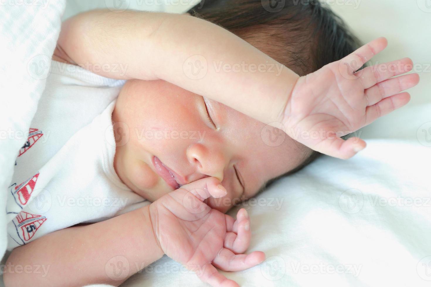 recém-nascido asiático dormindo na cama, saudável com a mãe para novo conceito de família foto