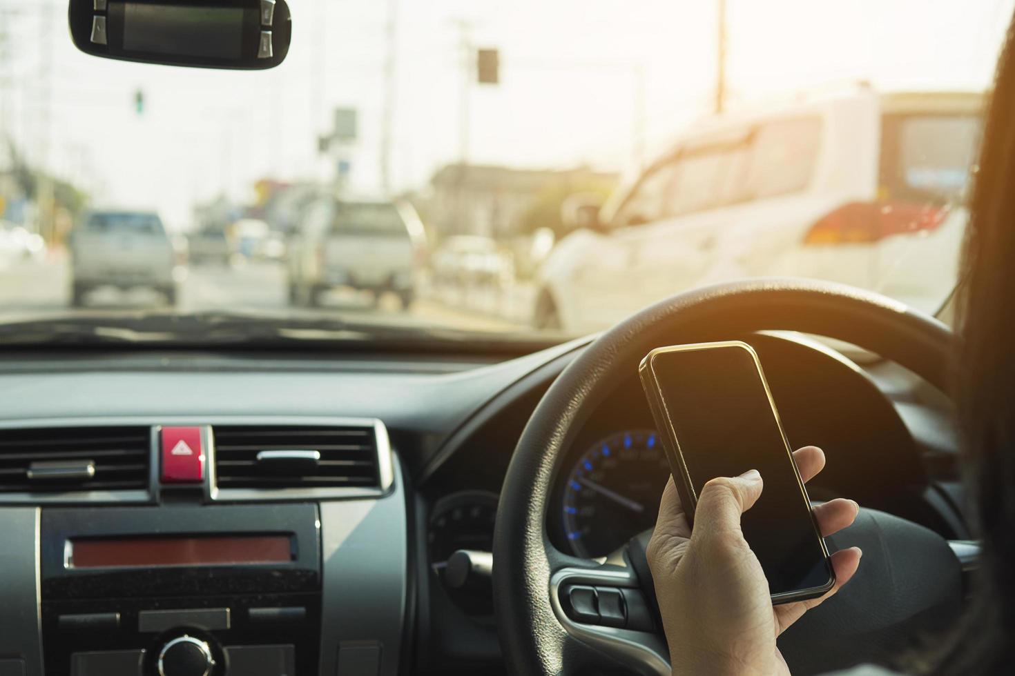 close-up de um homem dirigindo um carro perigosamente ao usar o telefone celular foto