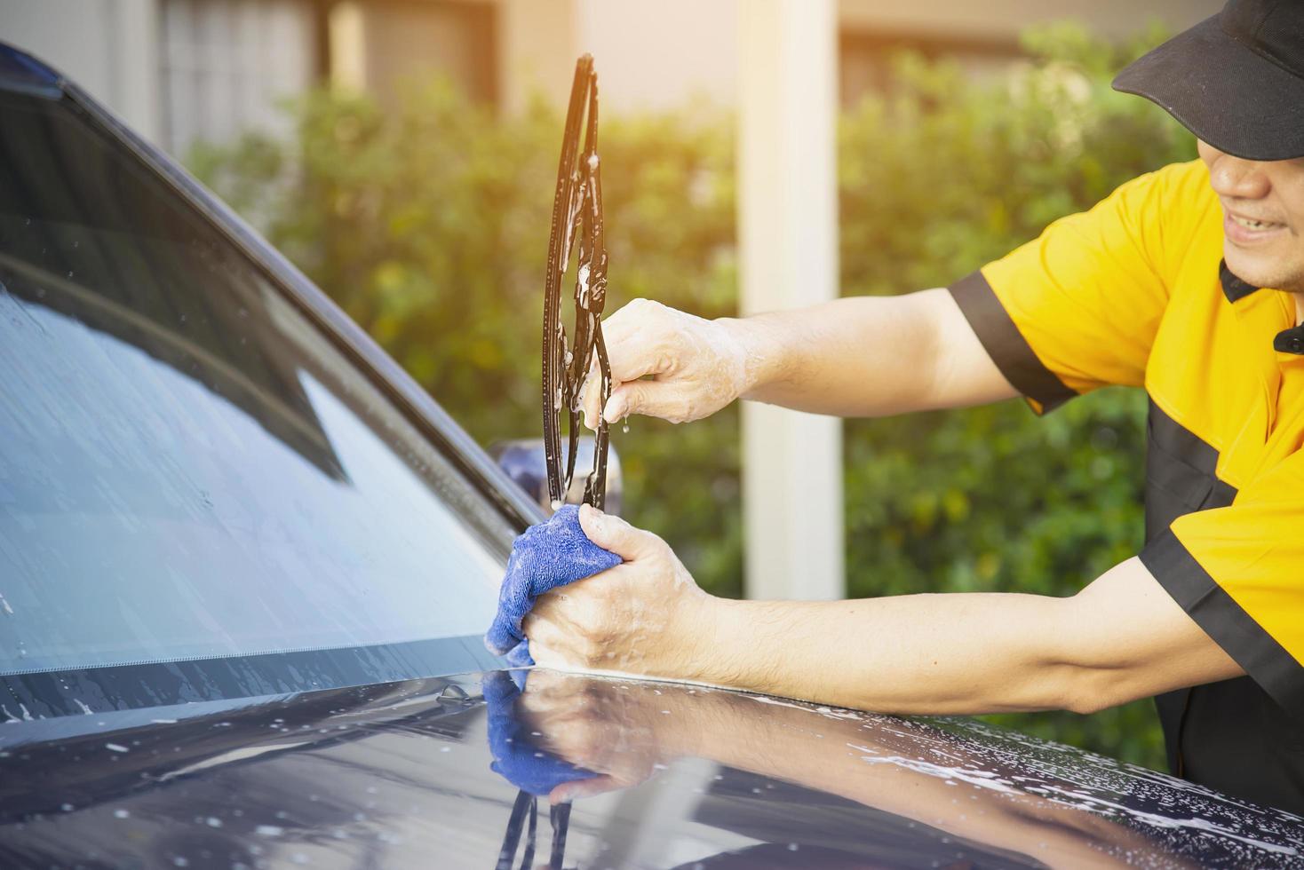 homem lavar carro usando shampoo - conceito de cuidado de carro de vida diária foto