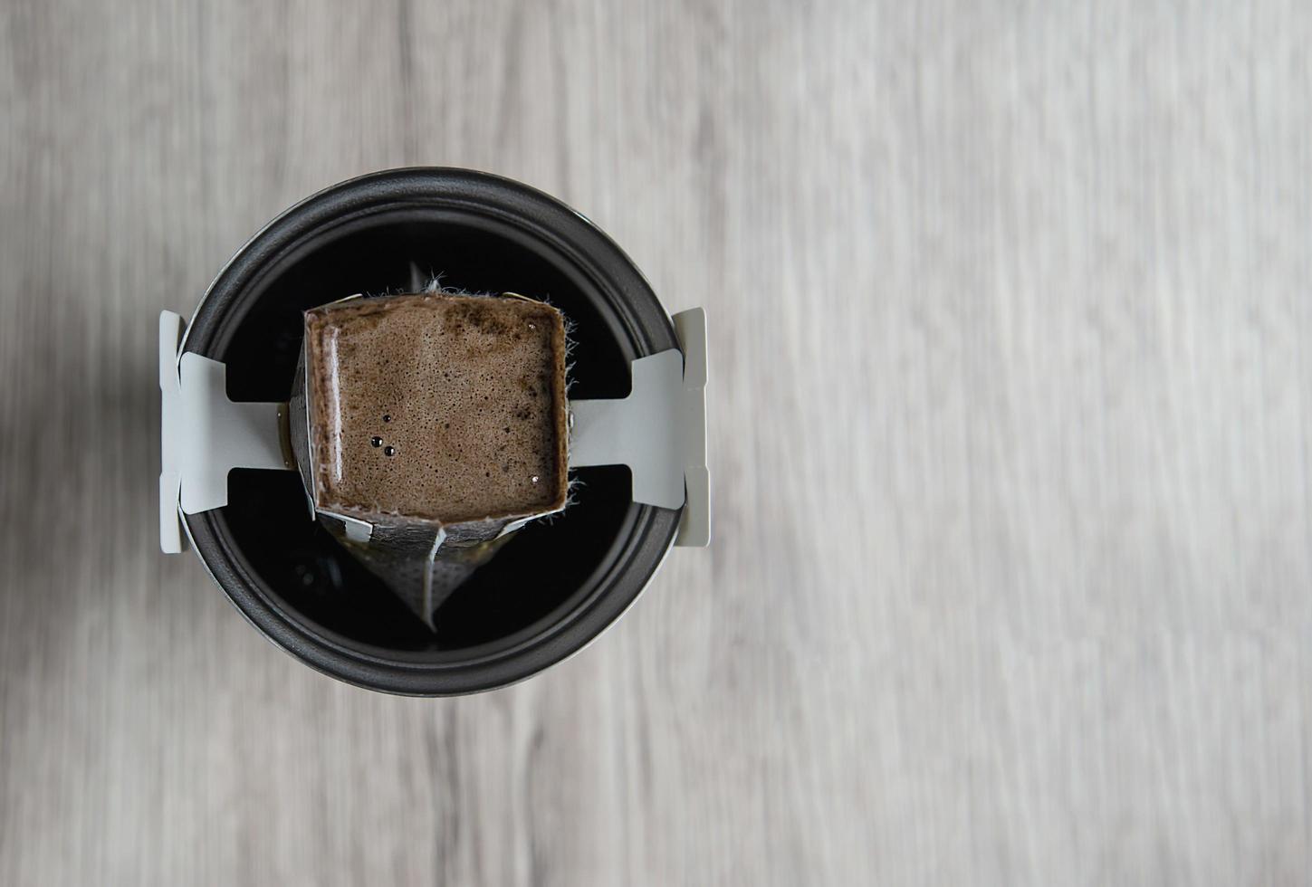 gotejamento de café em xícara de café quente de aço com espaço de cópia, conceito de cafeteira quente instantânea foto