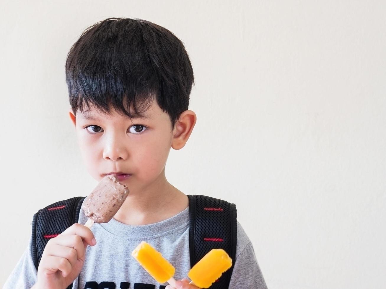 menino comendo sorvete. foto está focada em seus olhos.