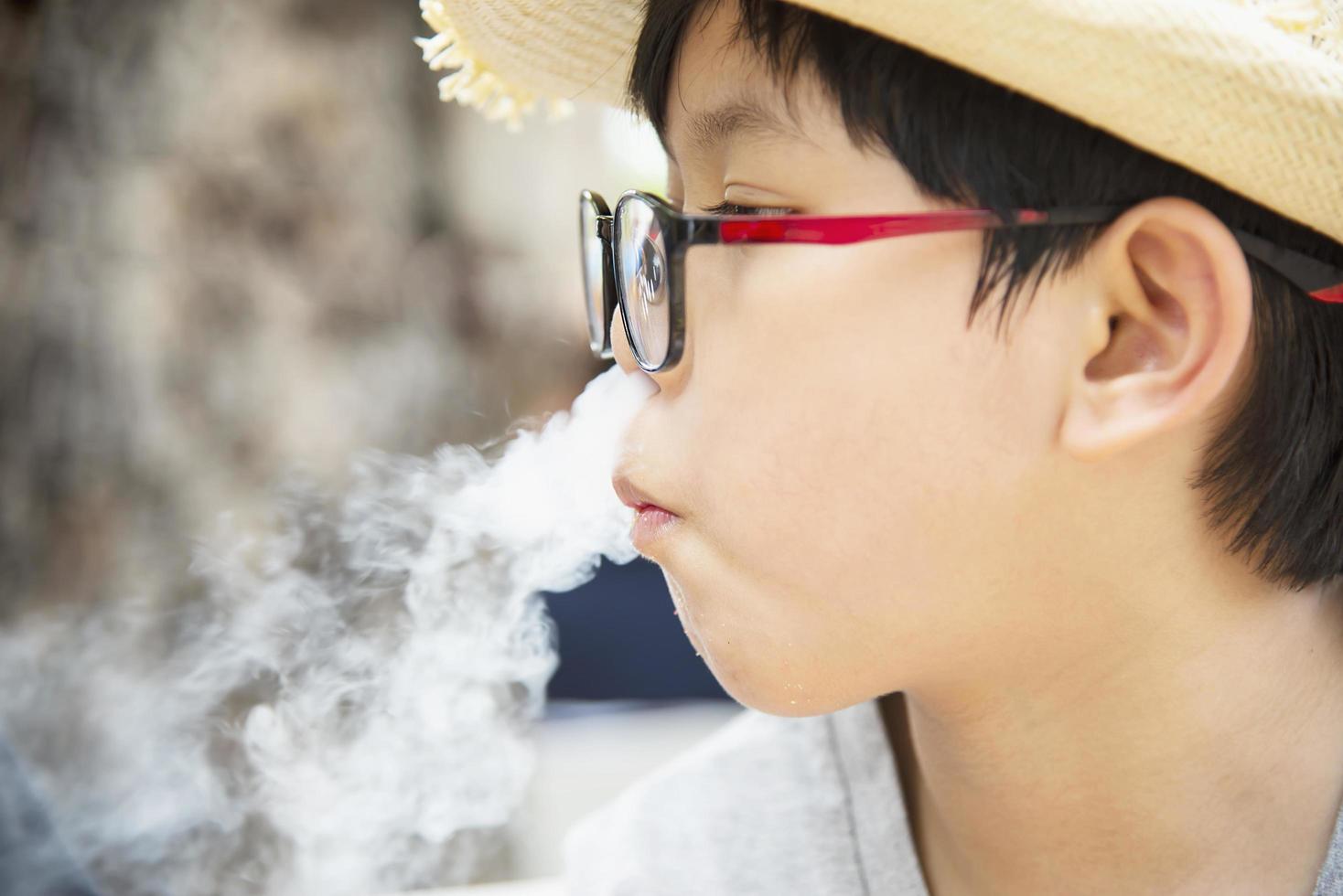 menino asiático comendo fumando canny alegremente - pessoas e lanche conceito de tempo feliz foto