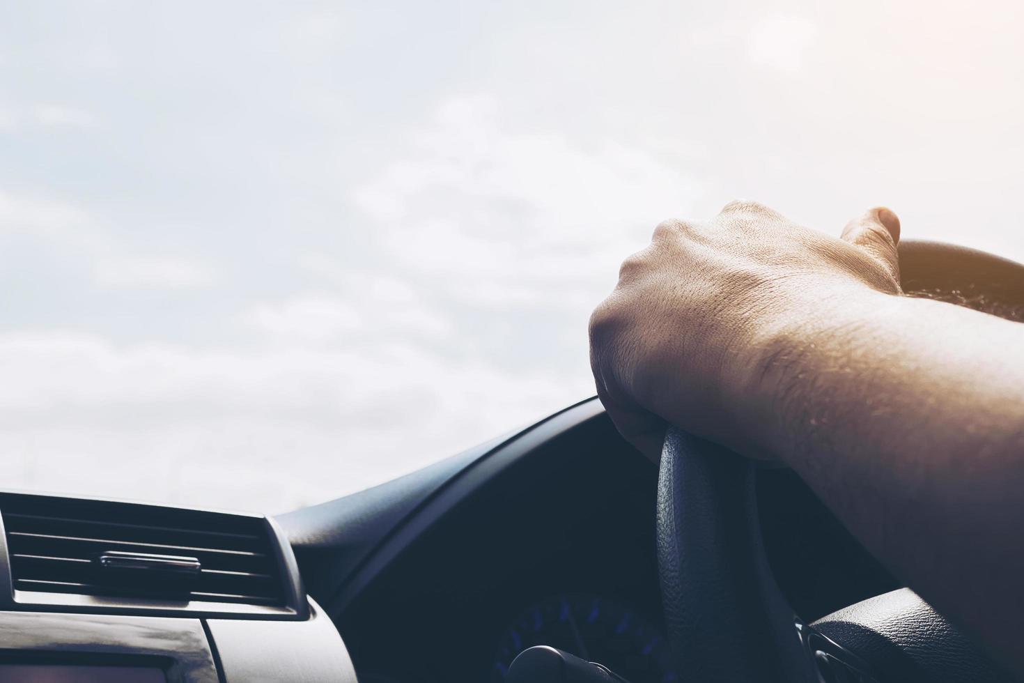 homem dirigindo carro com uma mão foto