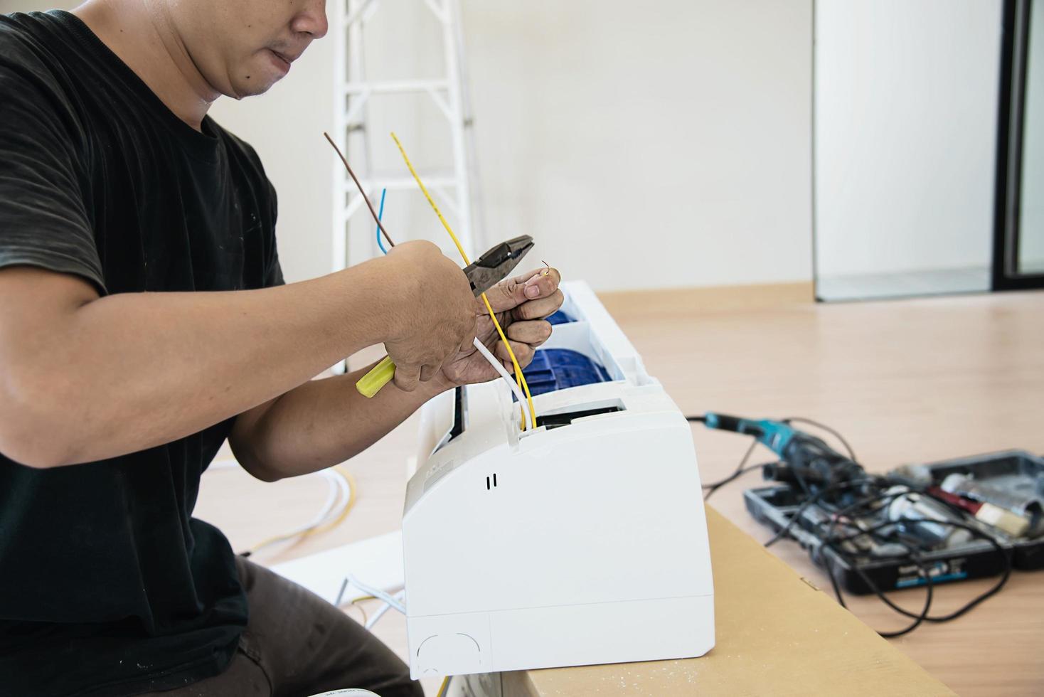 técnico está instalando ar condicionado durante a estação quente foto