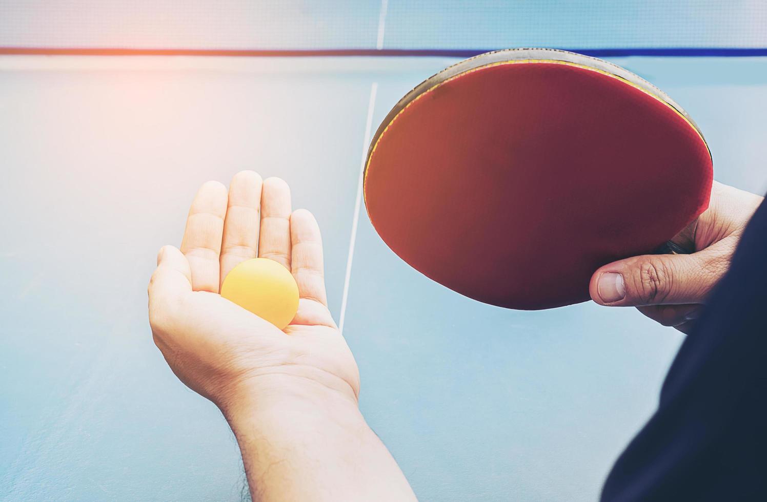 um homem joga tênis de mesa pronto para servir foto