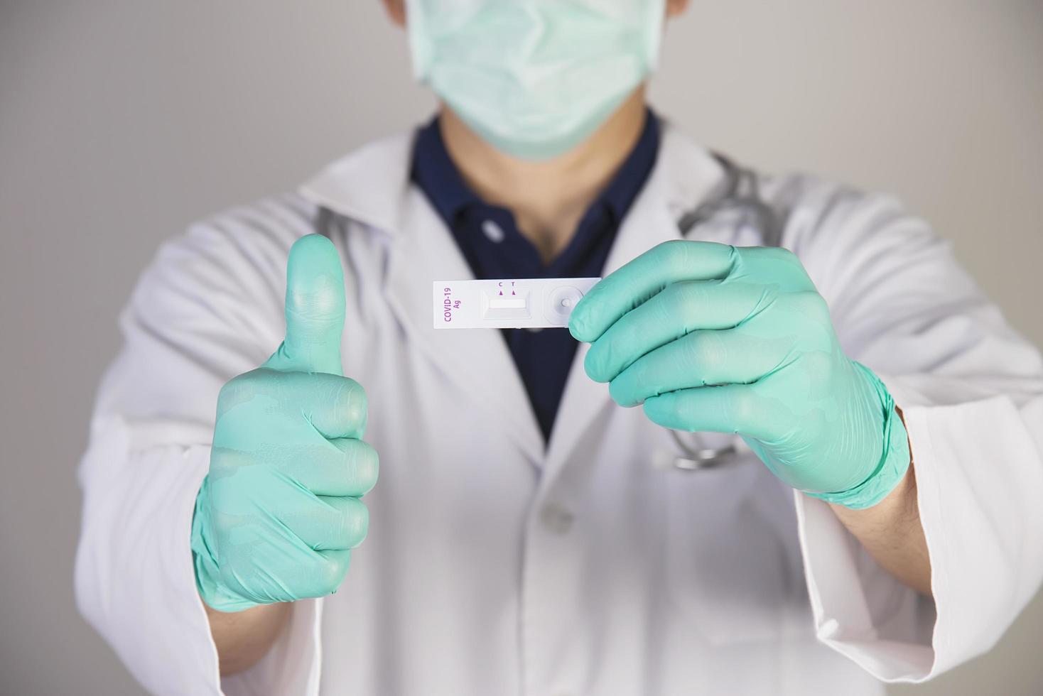 médico está mostrando conjunto de kit de teste de antígeno covid-19 foto