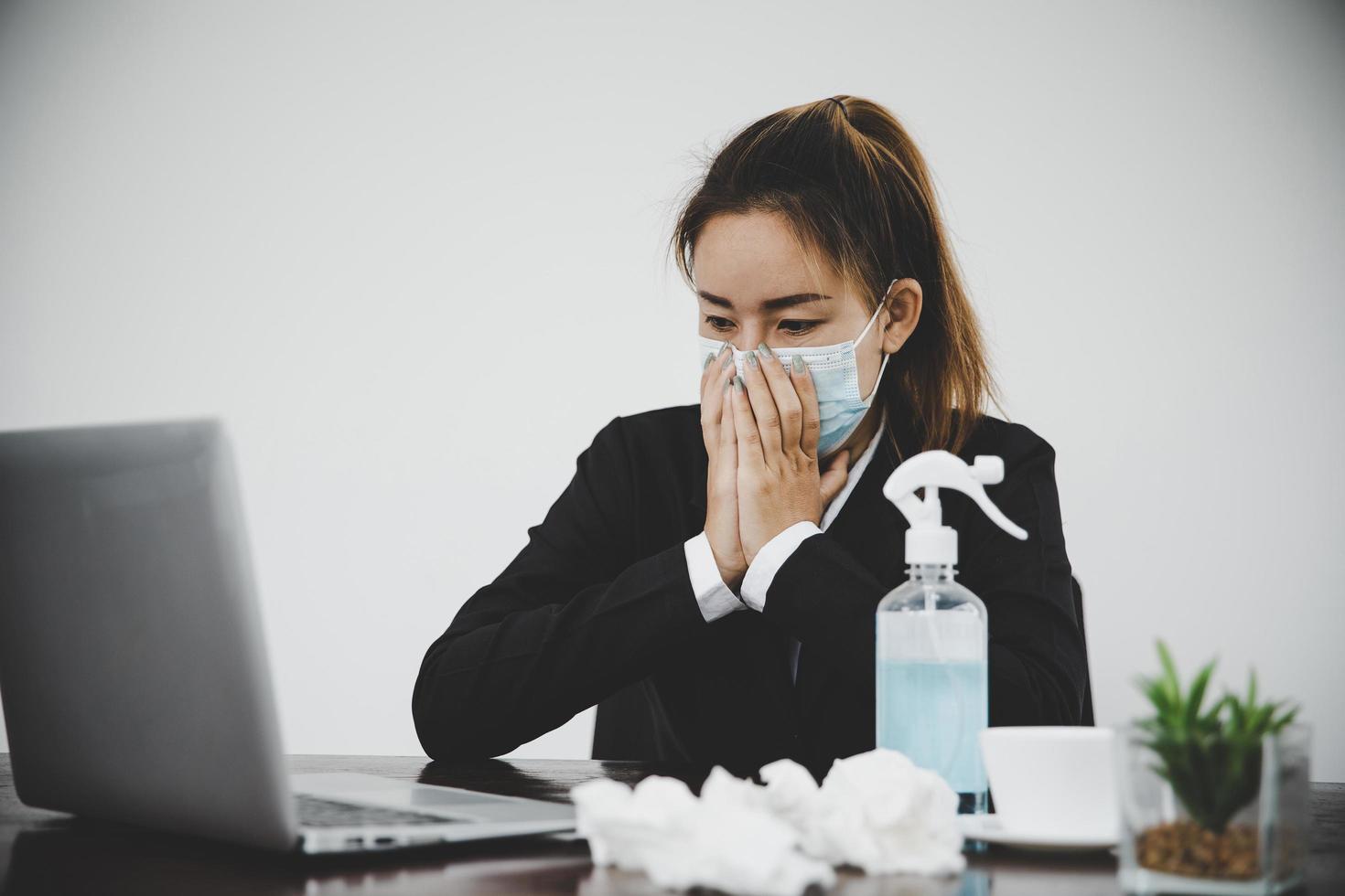 mulher de negócios asiática jovem doente usando máscara facial protetora foto