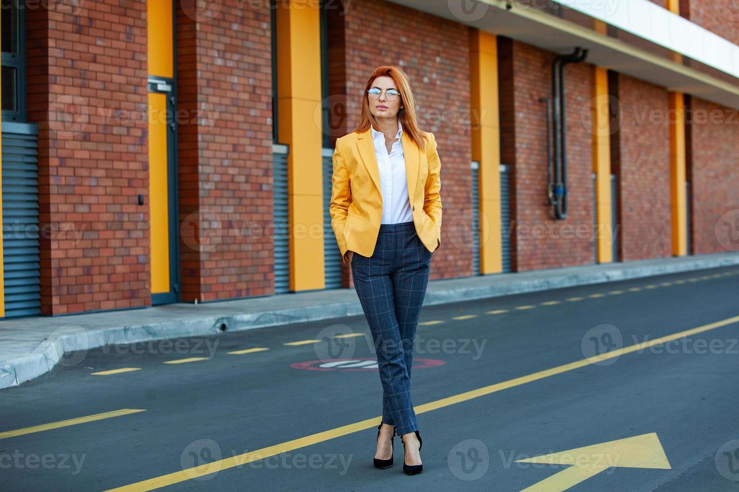 especialista em negócios confiante. feliz profissional bem sucedido posando perto do prédio de escritórios. garota europeia. senhora de negócios russo. conceito de líder de negócios feminino. retrato de mulher de negócios de sucesso foto