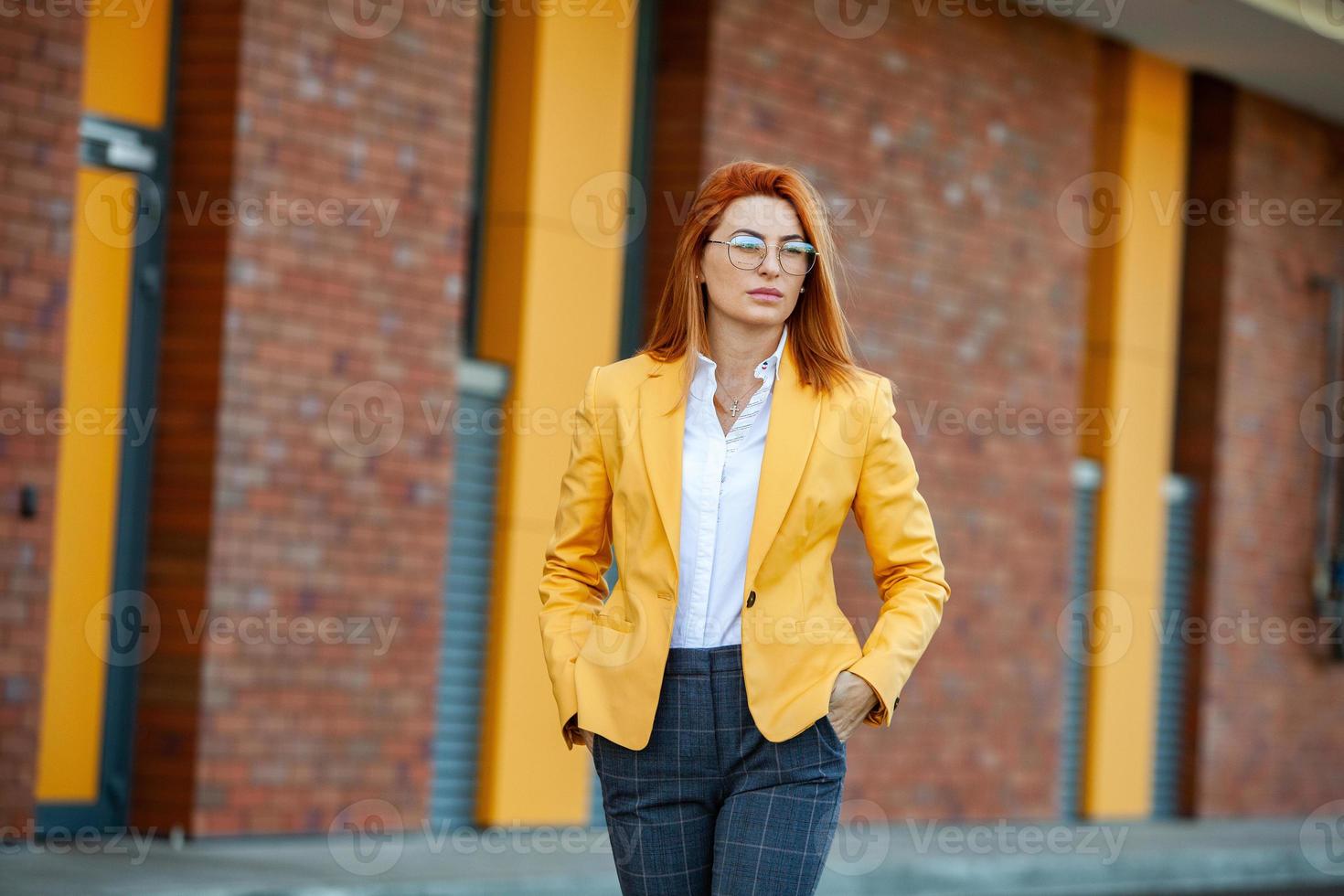 especialista em negócios confiante. feliz profissional bem sucedido posando perto do prédio de escritórios. garota europeia. senhora de negócios russo. conceito de líder de negócios feminino. retrato de mulher de negócios de sucesso foto