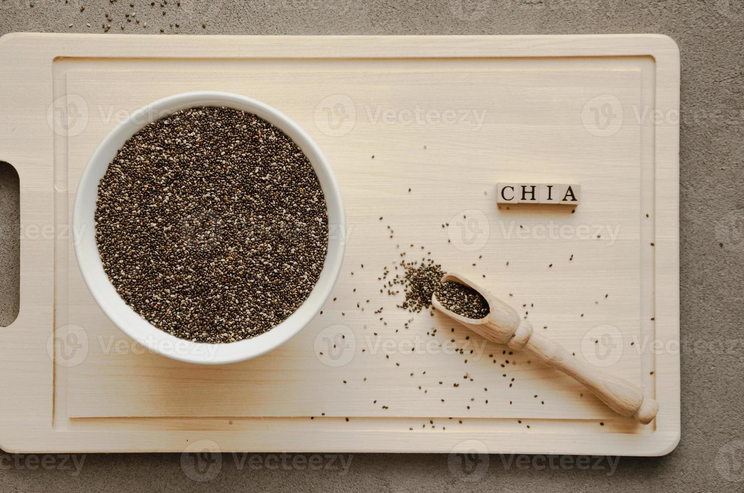 sementes de chia em uma placa de madeira com uma colher e uma inscrição, foto