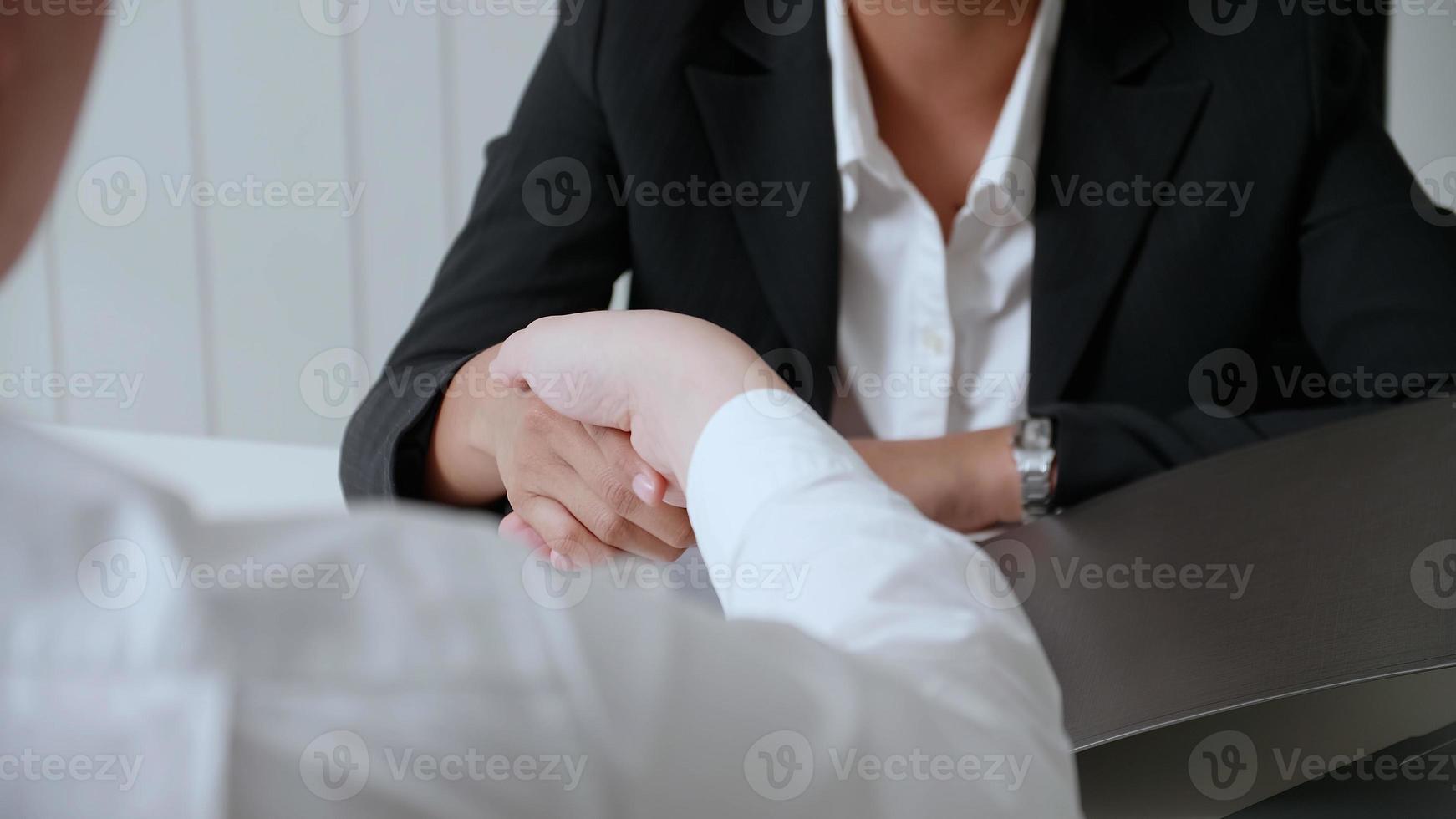 Empresários apertando as mãos, terminando uma reunião foto