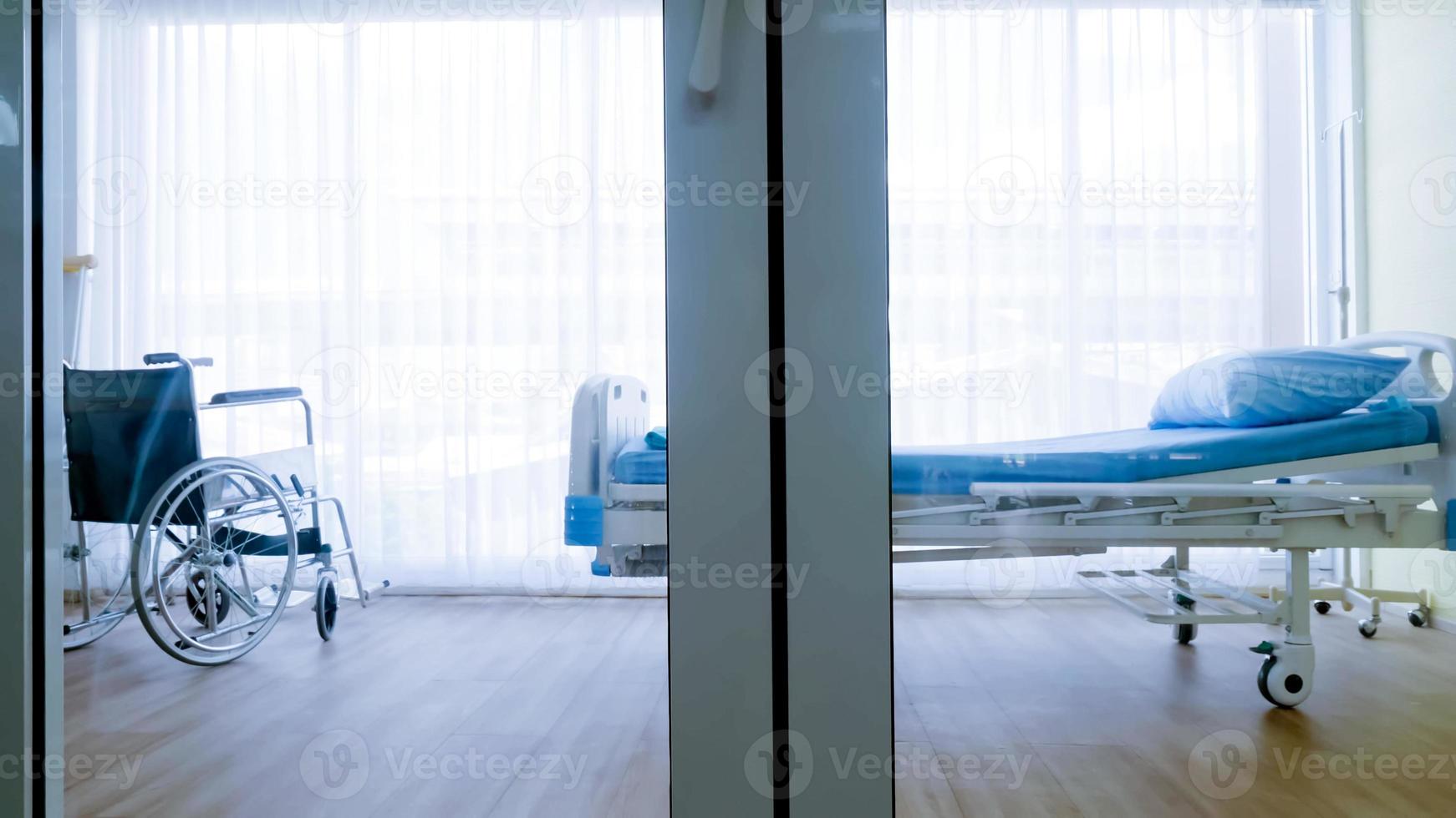 quarto para paciente em um hospital, cama vazia e cadeira de rodas na enfermaria do hospital. foto