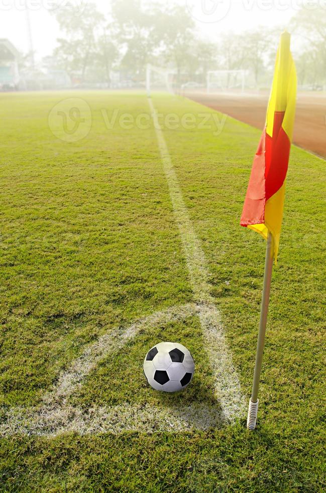 bandeira de canto com bola em um campo de futebol foto
