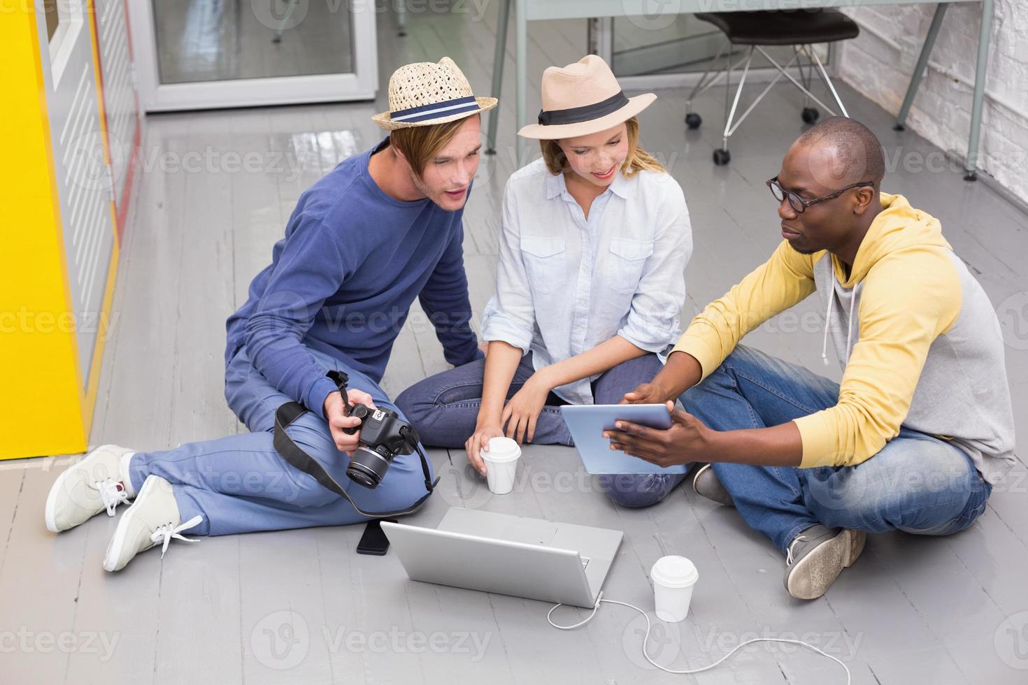 colegas casuais usando tablet digital no chão foto