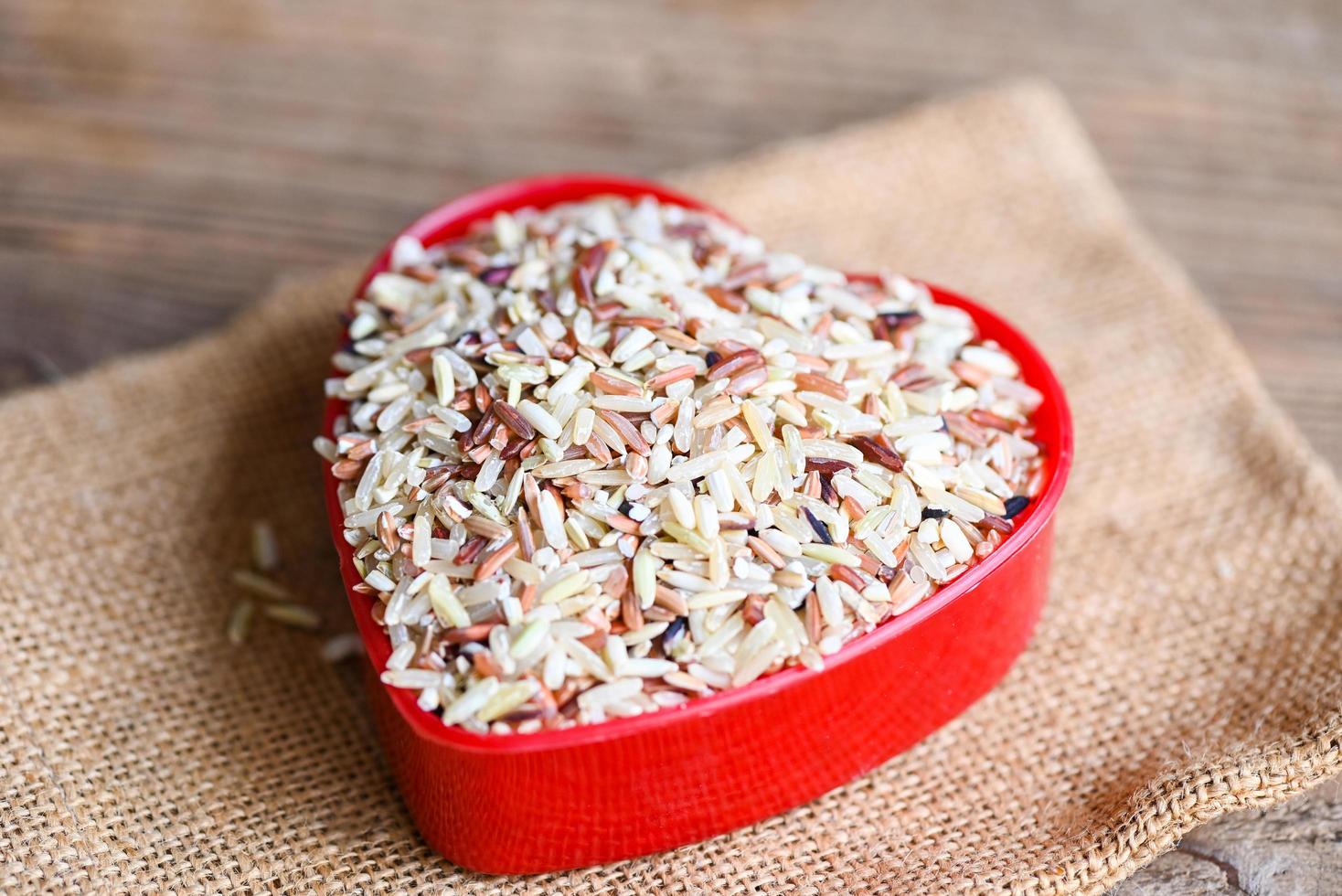 arroz de coração, arroz integral no saco, arroz tailandês misturado de várias cores para cozinhar alimentos, arroz loonzain marrom preto vermelho branco roxo fundo de alimentos saudáveis. foto