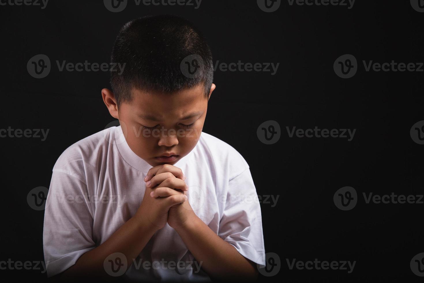 menino orando a deus em casa foto