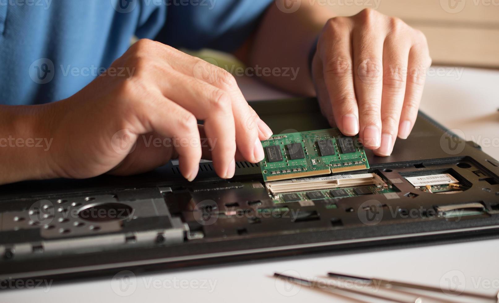 o engenheiro repara o laptop e a placa-mãe. instala o equipamento foto