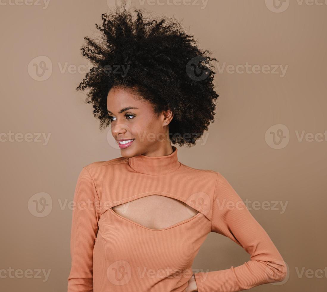 closeup de uma jovem afro latina sorridente. alegria, positivo e amor. lindo cabelo estilo africano. fundo de estúdio pastel. foto