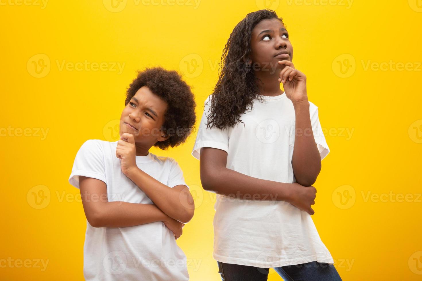 crianças pensativas sobre fundo amarelo. foto