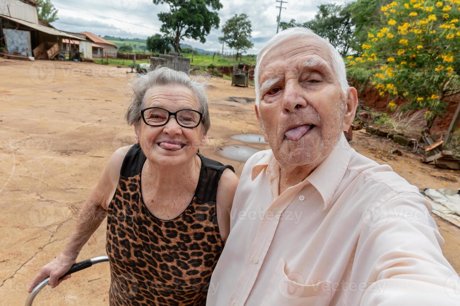 casal de agricultores idosos tirando foto com smartphone.