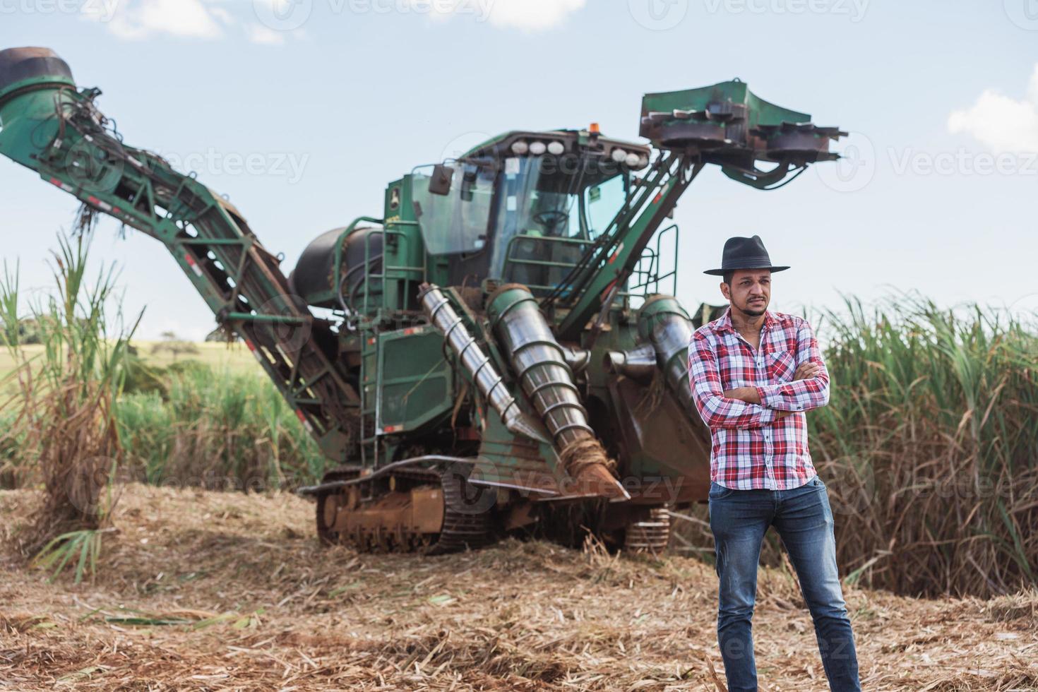 empresário rural verificando o trabalho. máquina colhedora de cana-de-açúcar. agricultor. foto