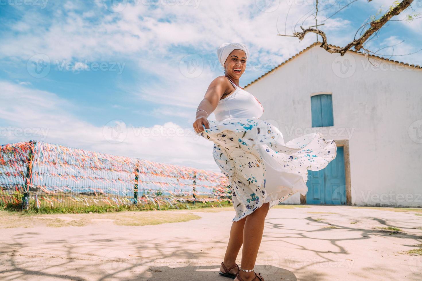 mulher brasileira feliz vestida com traje tradicional baiano dançando no centro histórico de porto seguro foto