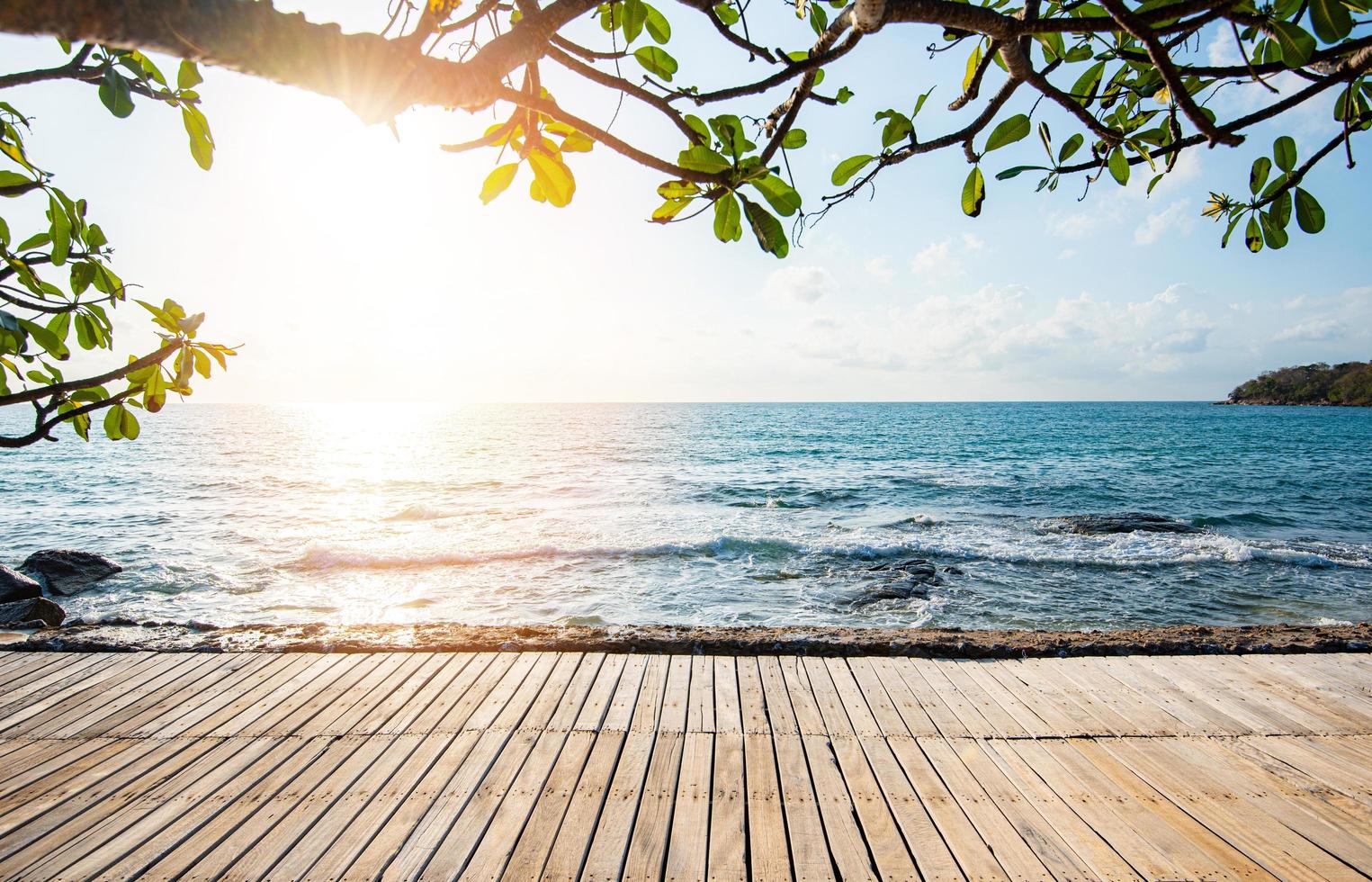 terraço vista mar com mesa de madeira vazia na praia paisagem natureza com pôr do sol ou nascer do sol - ponte de madeira varanda vista mar idílico litoral silhueta árvore tropical férias de verão praia foto