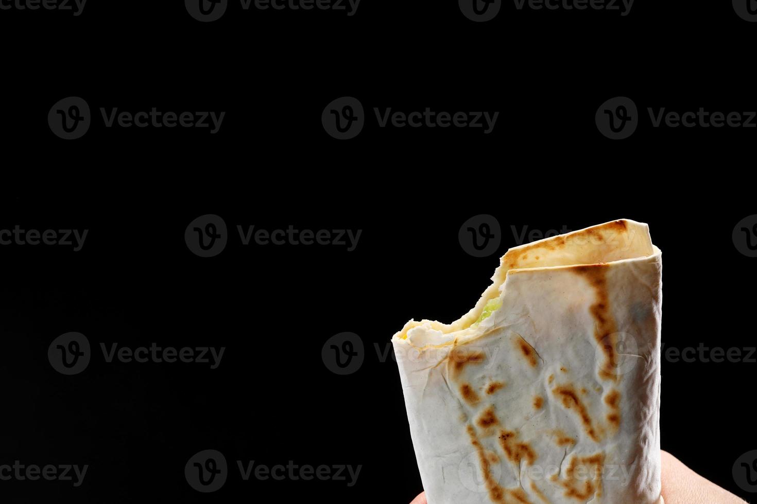 mordeu um pão pita, fajitas, burrito, shawarma em um fundo branco foto