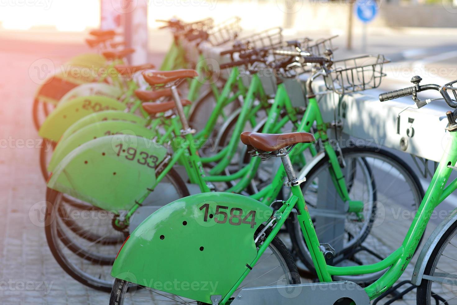 castellon, espanha, close-up do alinhamento de bicicletas de aluguel estacionado na estação na rua. foto de alta qualidade