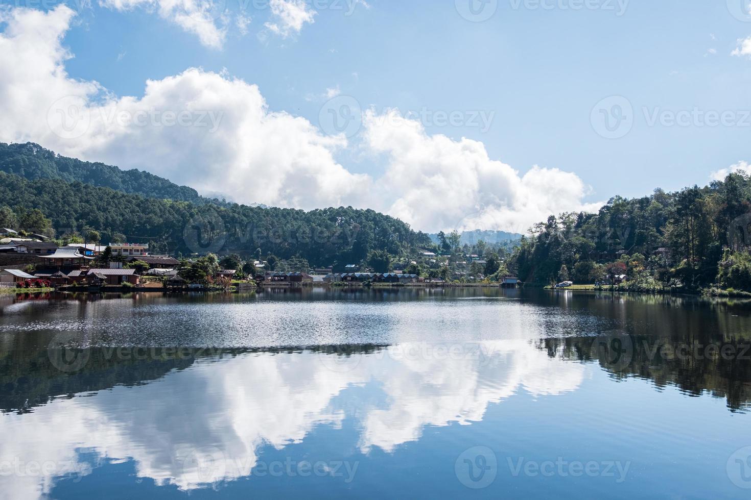 reflexo do céu do pequeno reservatório na vila rural. foto