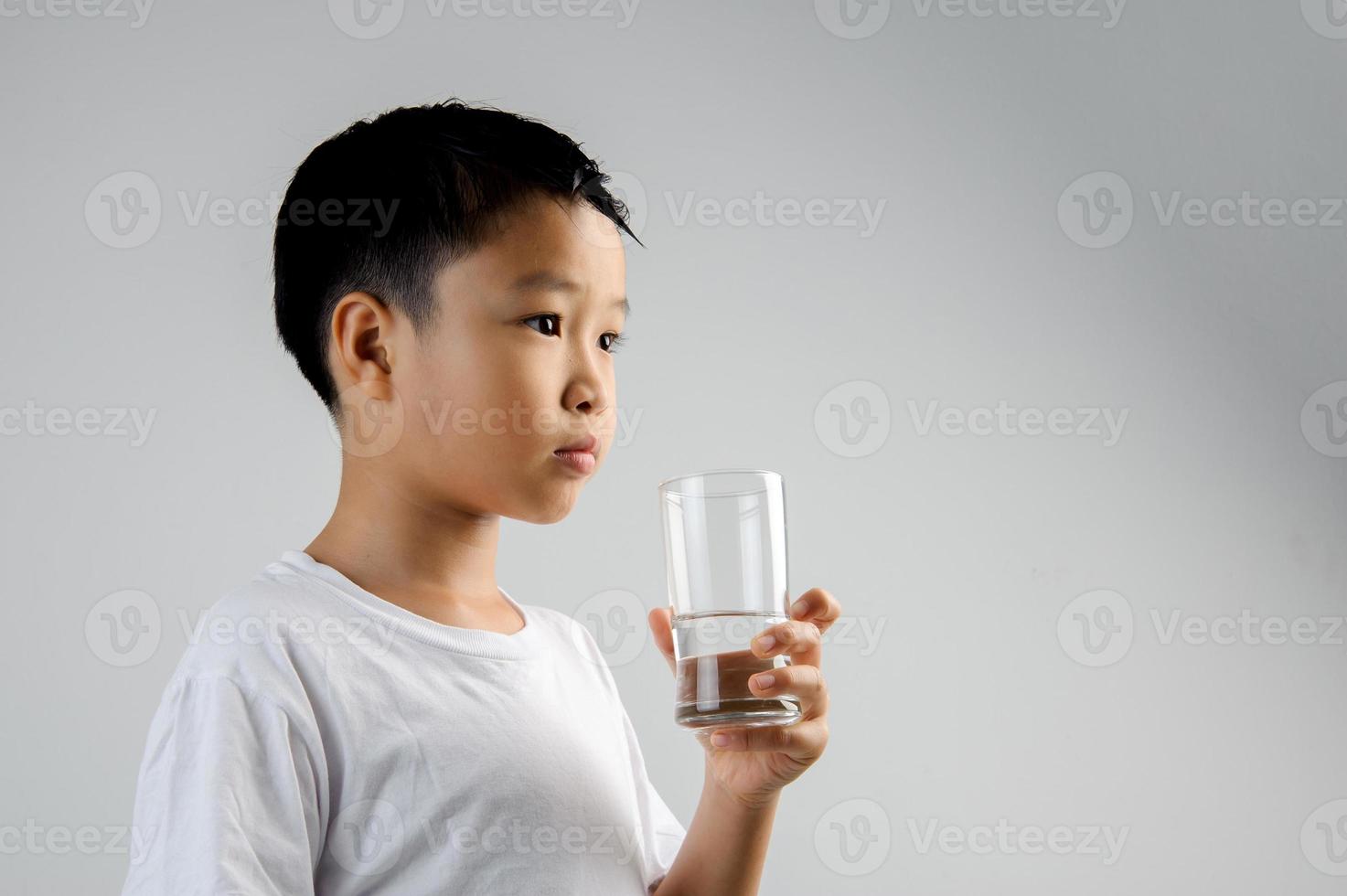menino beber água de vidro foto