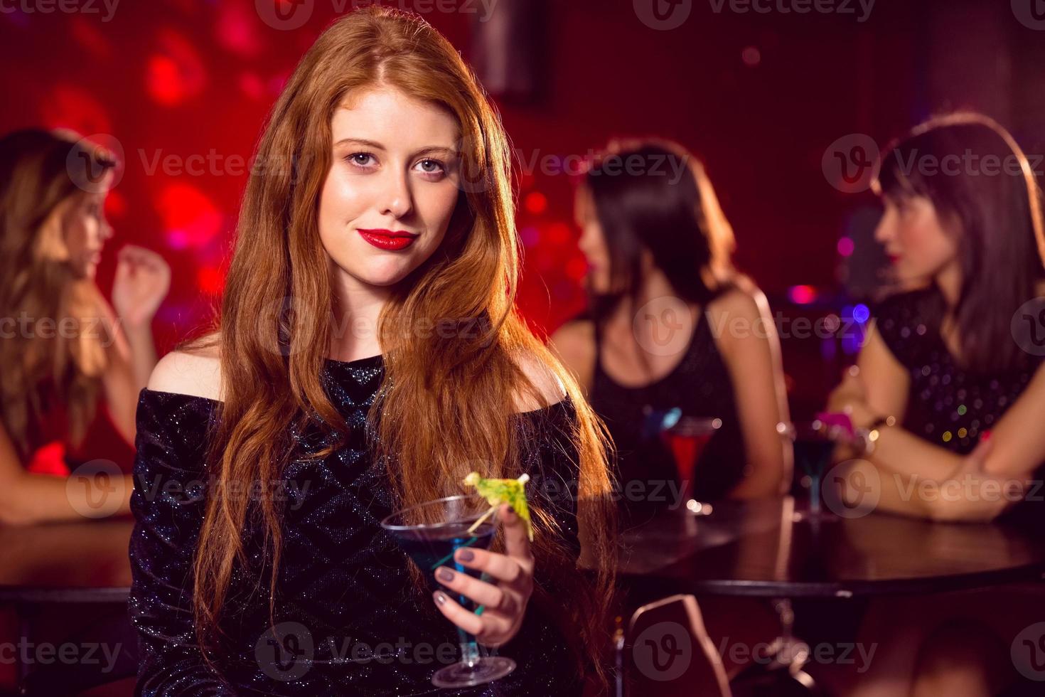 ruiva bonita bebendo um cocktail foto