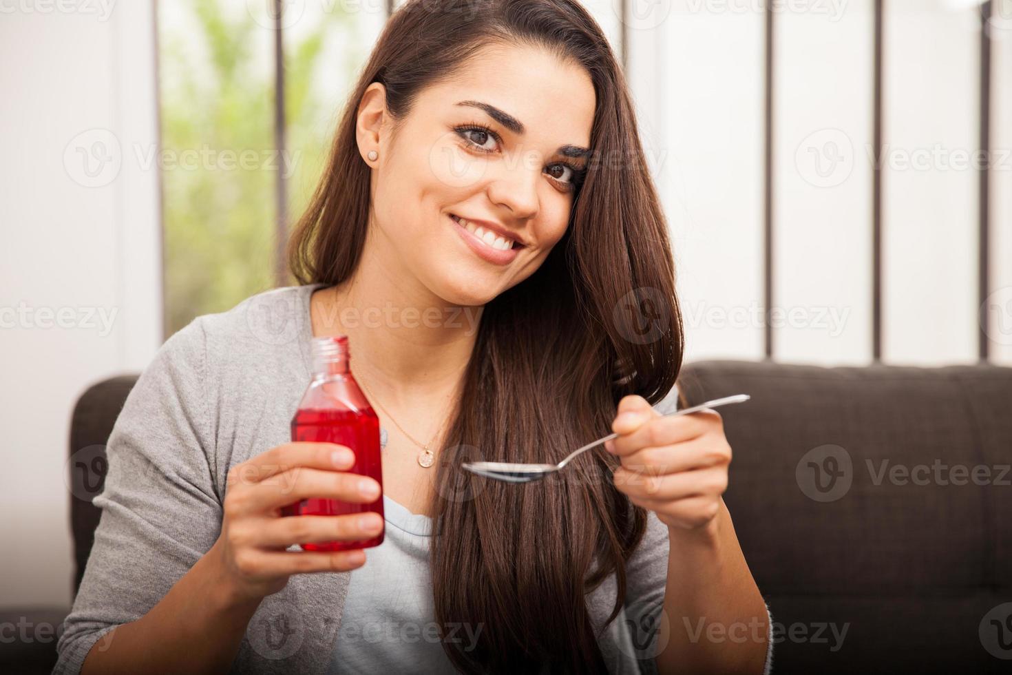 menina feliz bebendo xarope para tosse foto