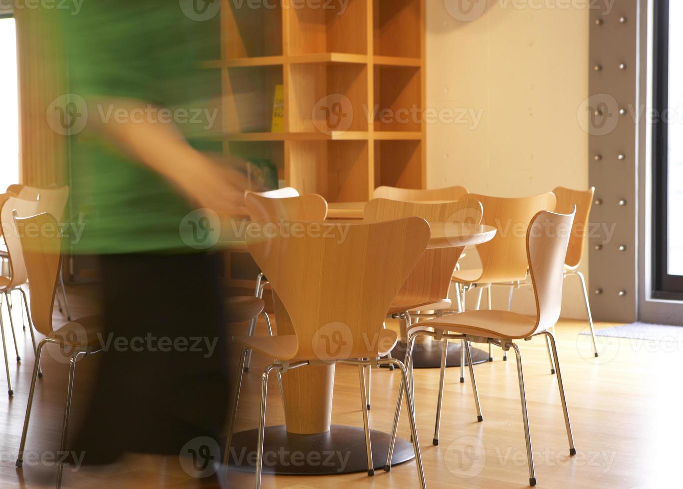 mulher andando perto de mesas e cadeiras foto