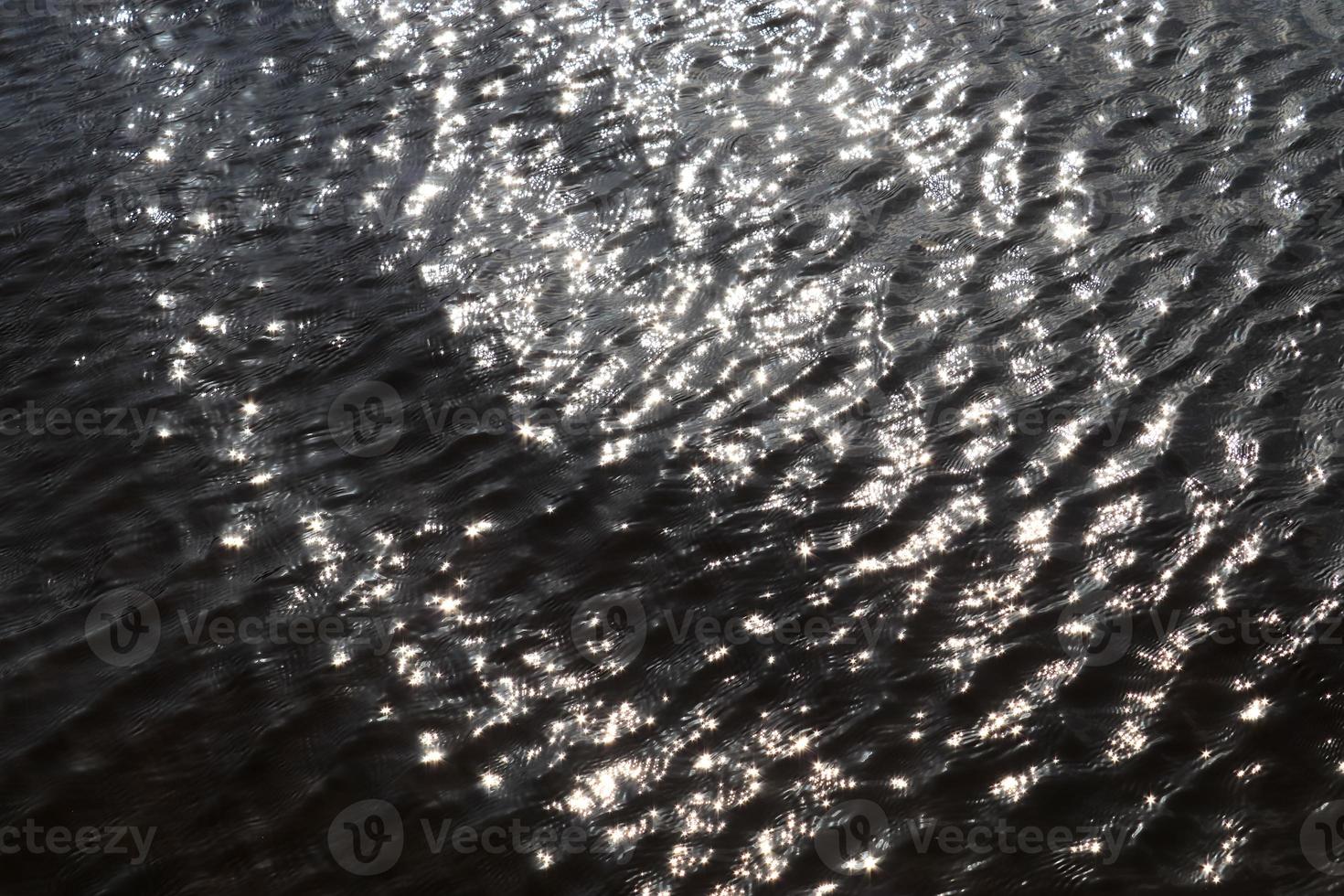 vista detalhada de perto em superfícies de água com ondulações e ondas e a luz do sol refletindo na superfície foto
