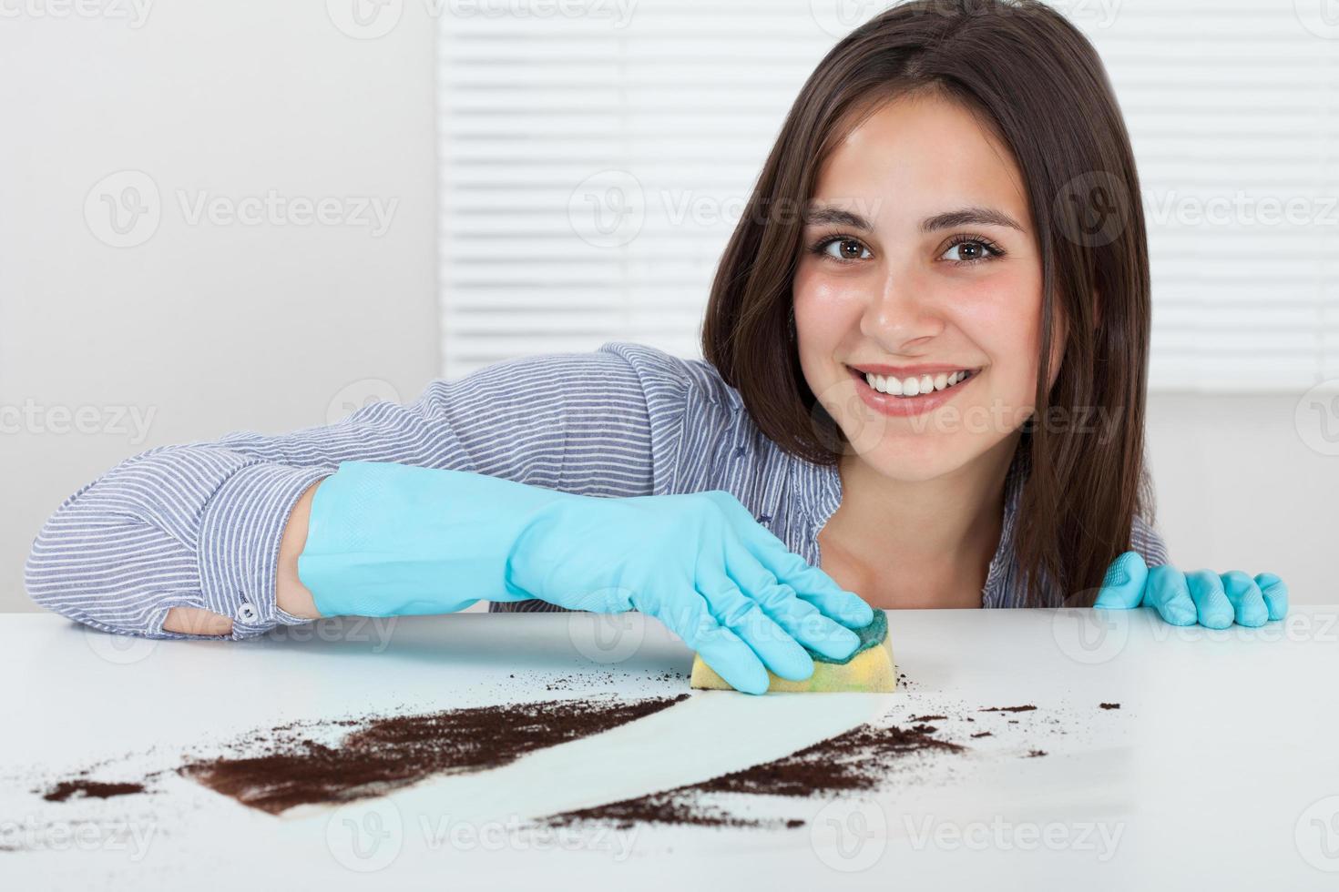 mão limpeza sujeira na mesa com esponja foto