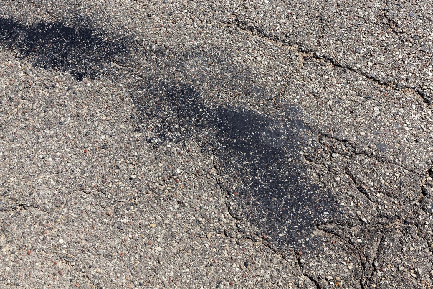 uma estrada de asfalto com muitos buracos e danos foto