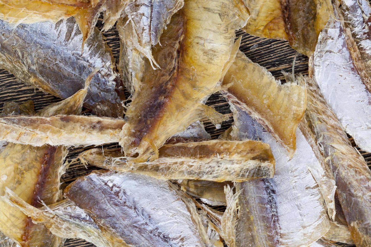 peixe pequeno seco e massacrado em uma mesa de madeira foto