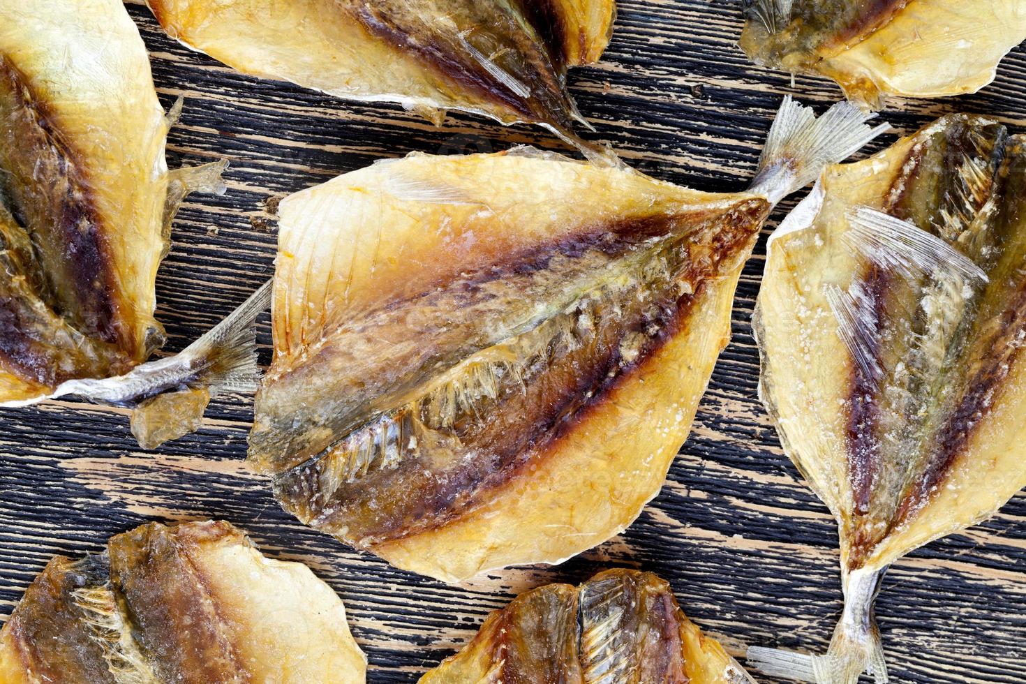 peixe pequeno seco e massacrado em uma mesa de madeira foto