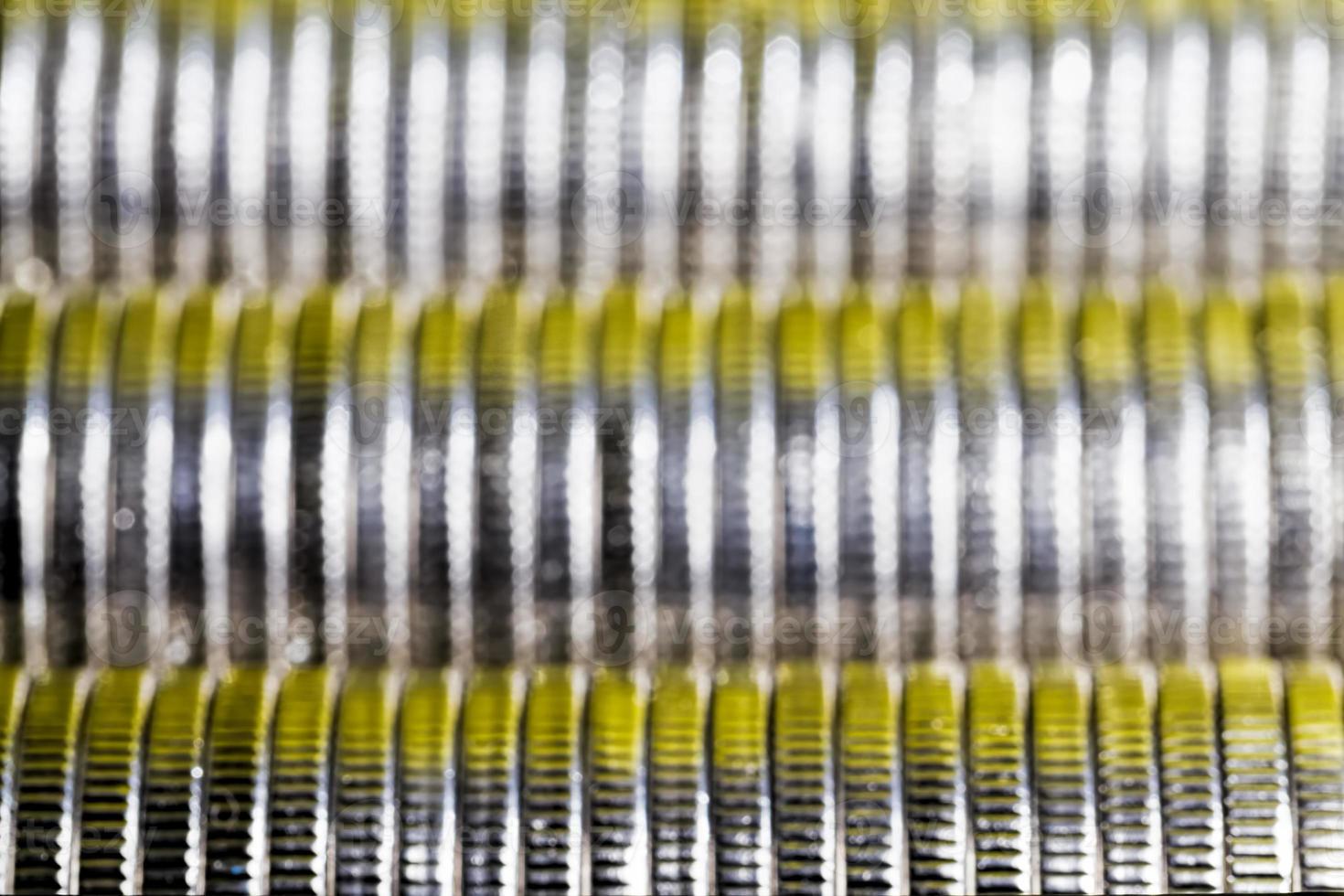 muitas moedas de metal redondas de cor prata iluminadas em amarelo foto