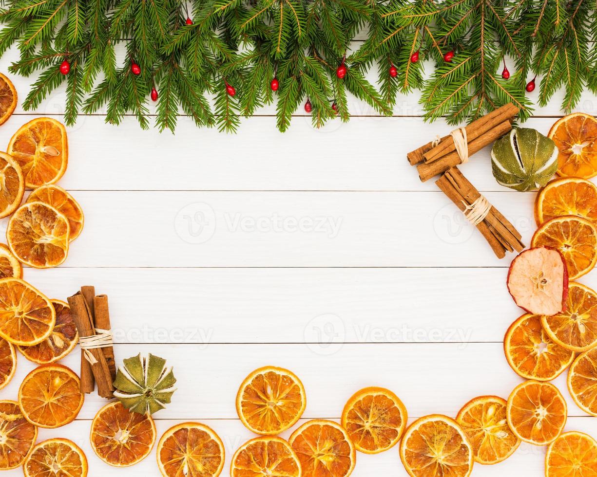 árvore de Natal, laranjas secas, canela, fundo branco de madeira, copie o espaço. foto