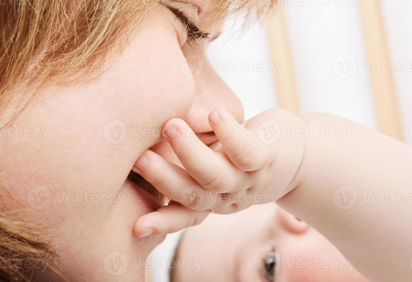 mamãe beijando a mãozinha do bebê foto