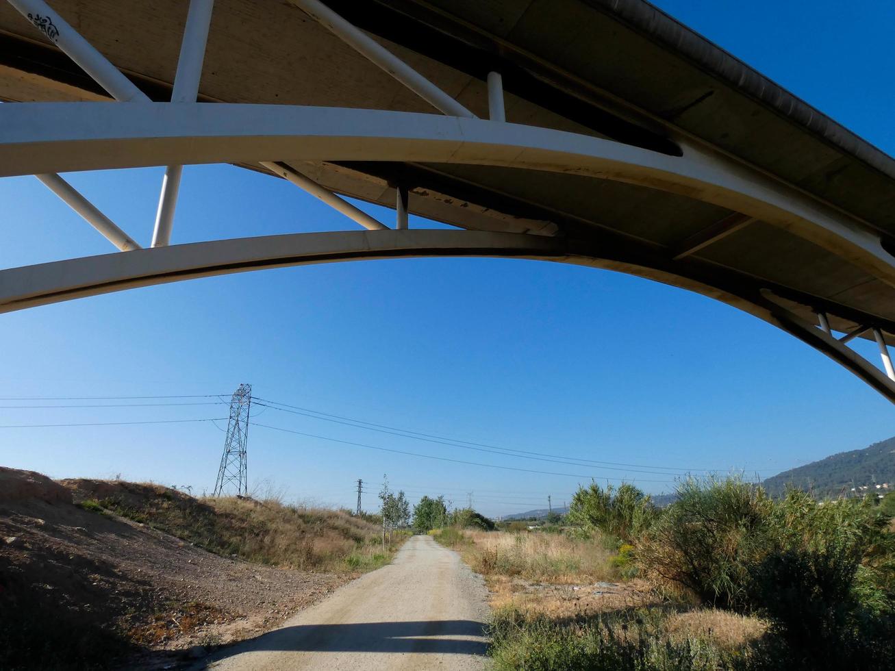 silhueta do arco de uma ponte moderna sobre uma estrada foto