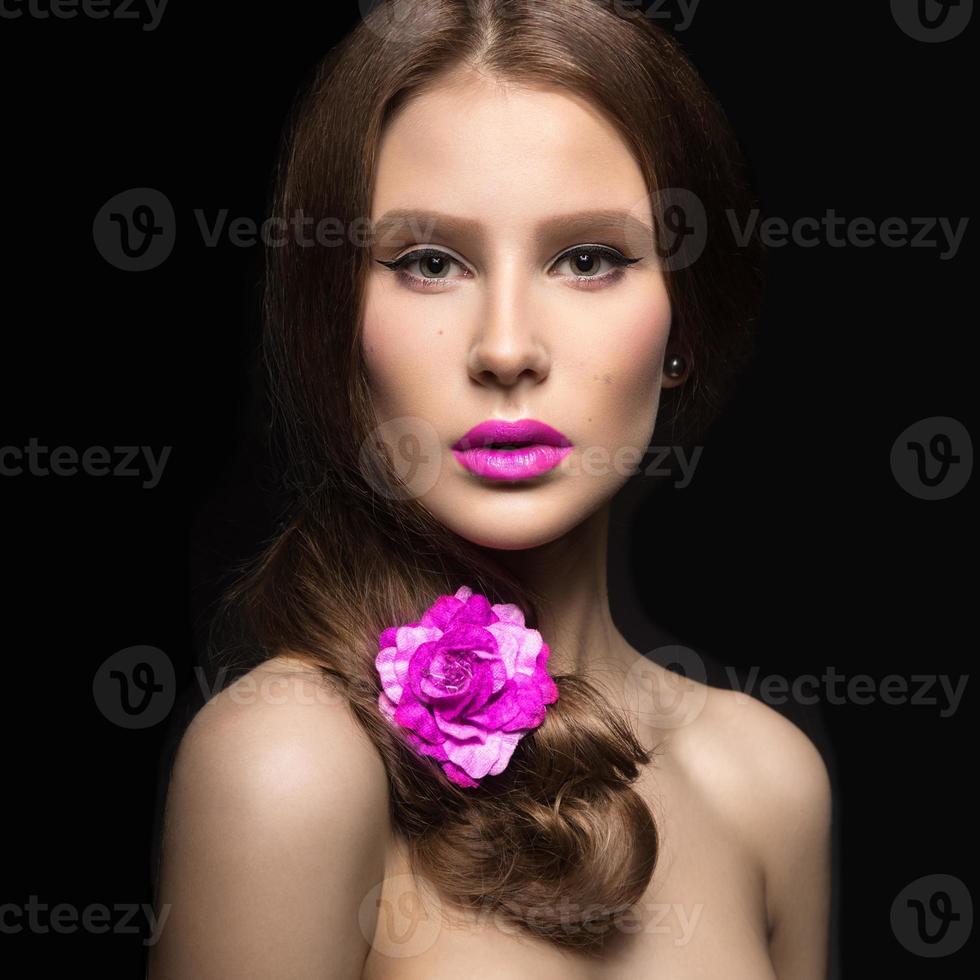 linda garota com os lábios cor de rosa e uma rosa foto