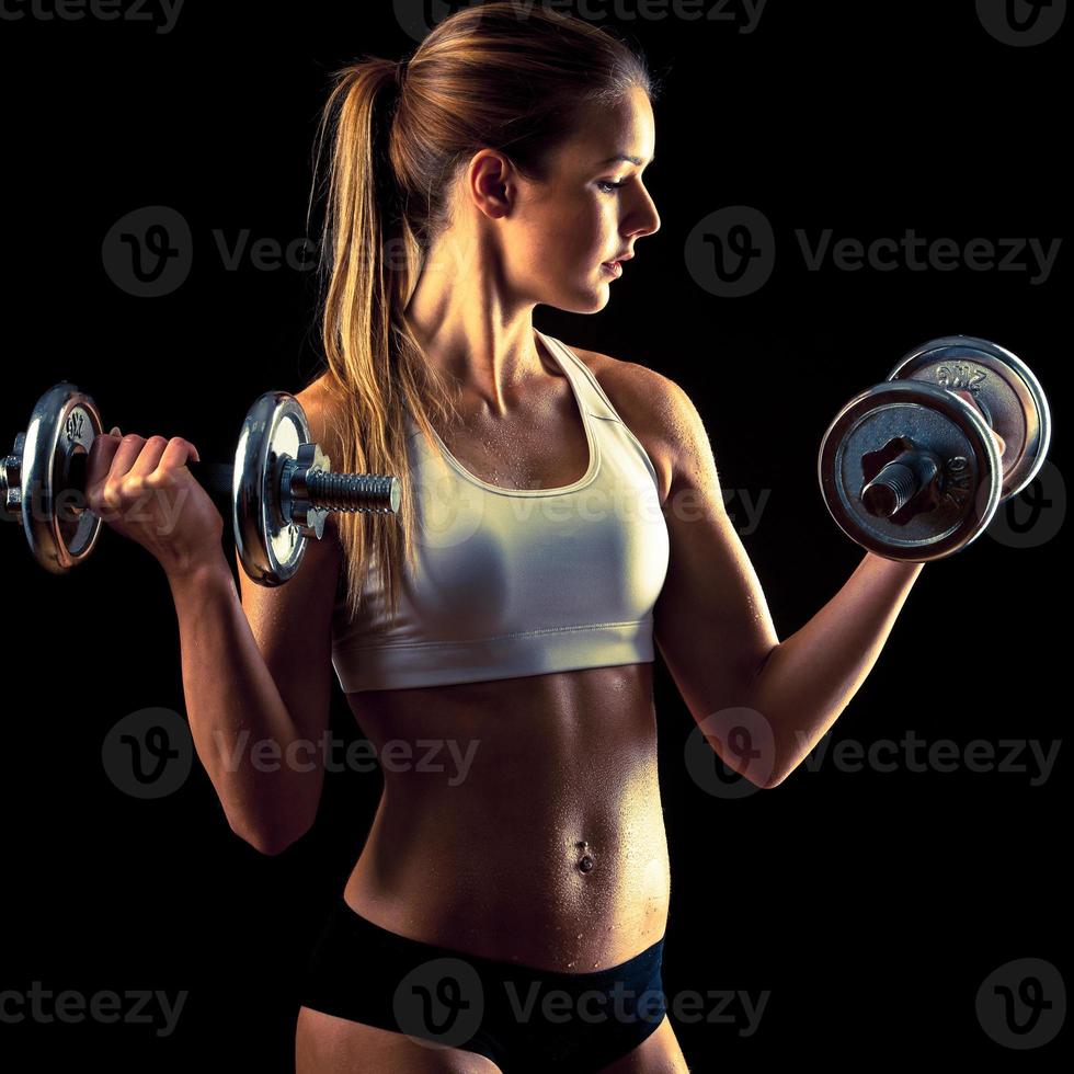 garota fitness - mulher jovem e atraente malhar com halteres foto