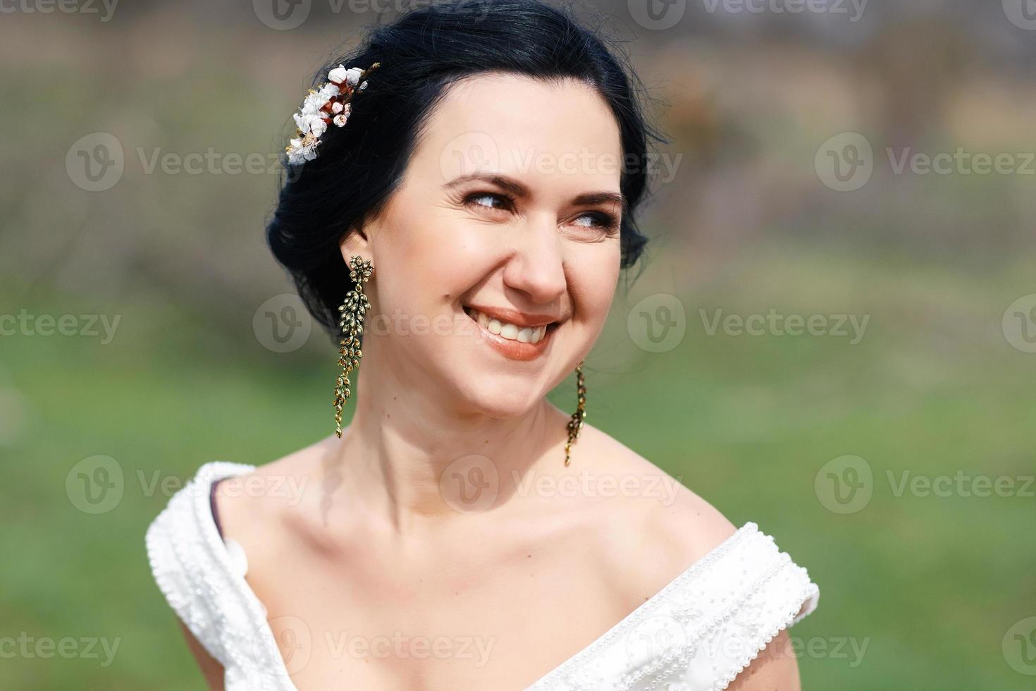 a noiva rindo feliz com flores no cabelo foto
