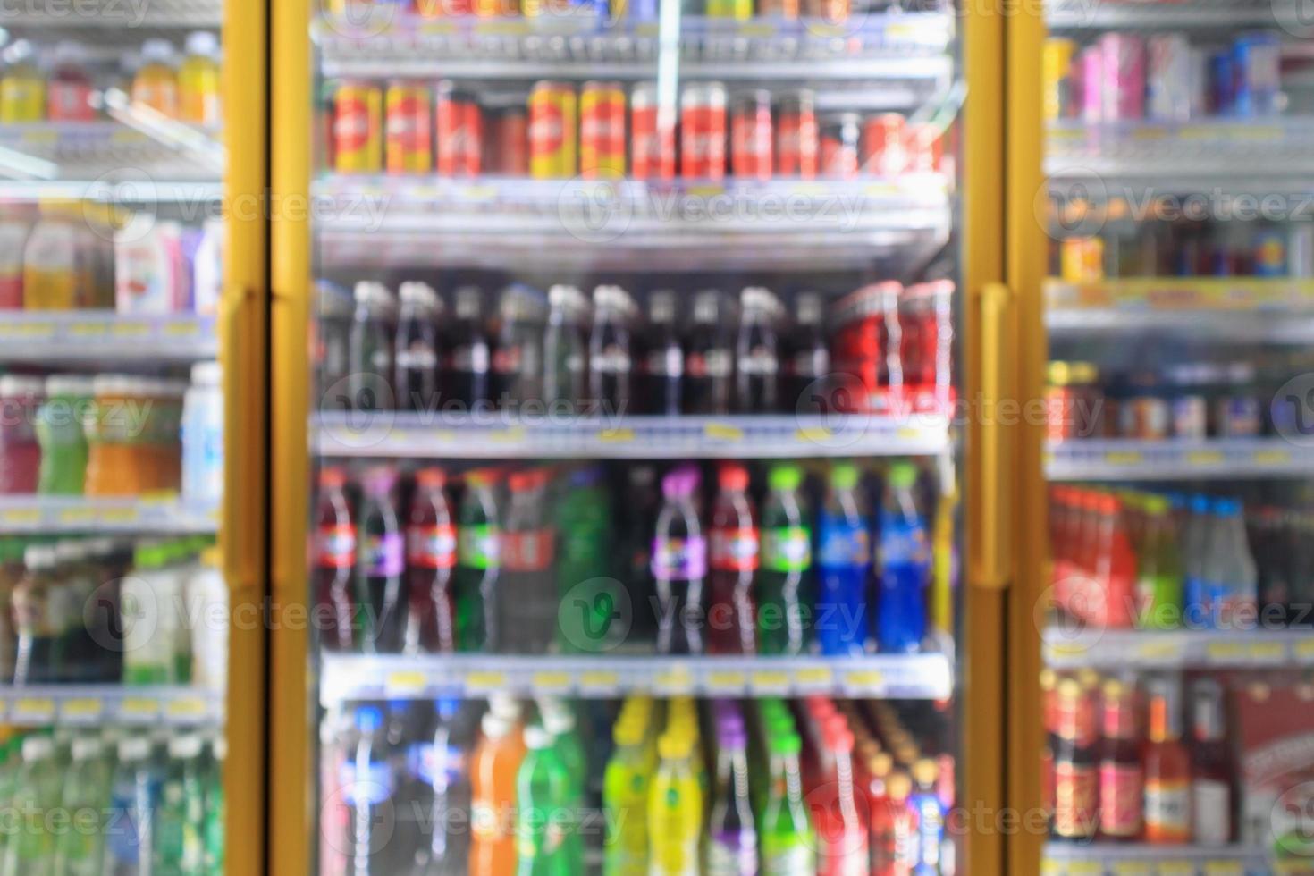 geladeiras de loja de conveniência de supermercado com garrafas de refrigerante nas prateleiras abstrato desfocar o fundo foto