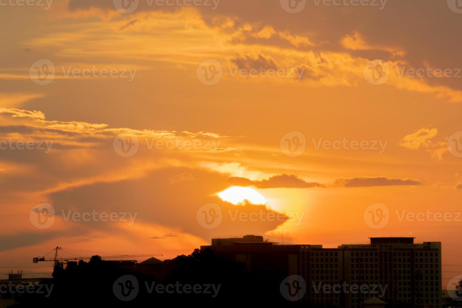 dá uma sensação calorosa, pôr do sol atrás do prédio da cidade, prédios altos da cidade de silhueta, silhueta de construção novamente belo fundo do céu e conceito de liberdade. foto