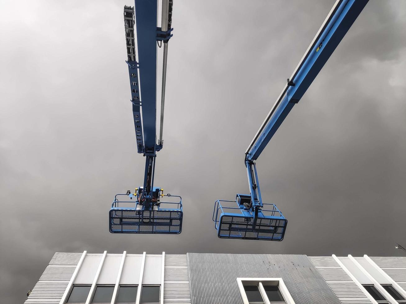 guindaste manlift com plataforma de elevação ao topo do telhado de um edifício foto