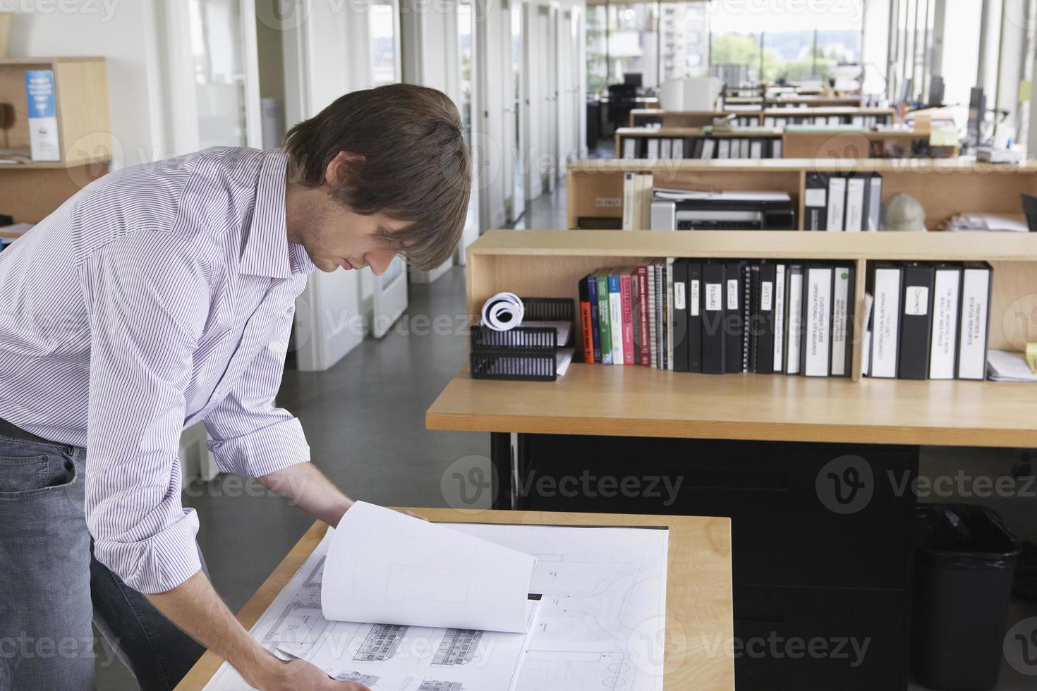 homem estudando blueprint no escritório foto